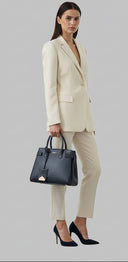 Blue handbag with gold accents on a light gray background
