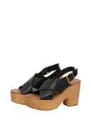 Black platform sandals with wooden sole on a white background