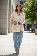 Handbag with geometric pattern and decorative handle on a white background